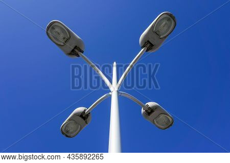 Photo Of 4 City Street Light Lamps On A Background Of Blue Clear Sky.