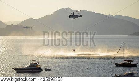 Russian KA-32 helicopter draws water from the sea to extinguish a forest fire. 30 July, 2021. Marmaris,Turkey