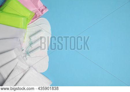 Menstrual Pads, Tampons And Pantyliners On Light Blue Background, Flat Lay. Space For Text