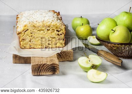 Apple And Coconut Oaf Cake On Wooden Cutting Board And Apples In A Vase