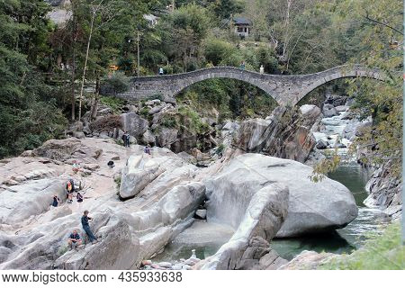 Lavertezzo, Switzerland -  September 17, 2021: People Enjoy The Magnificent Double-arched Stone Brid