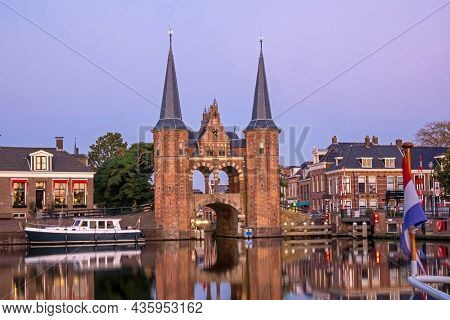 The watergate in the historical city Sneek in Friesland the Netherlands at sunset with the dutch flag