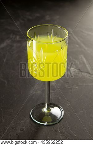 Textured Vintage Glass With Limoncello Or Poncha Drink On A Dark Concrete Surface