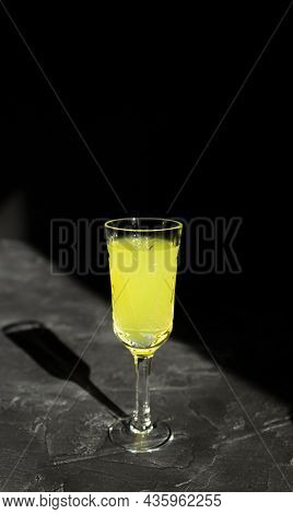 Limoncello Liqueur Or Poncha Drink With Copy Space On Black Surface In Bright Sunlight With Hard Sha
