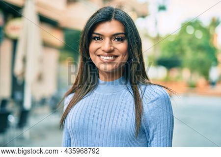 Beautiful hispanic woman smiling confient at the city