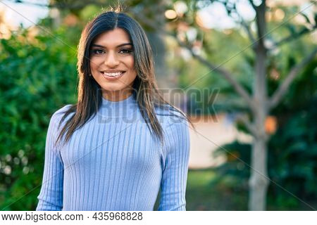 Beautiful hispanic woman smiling confient at the park