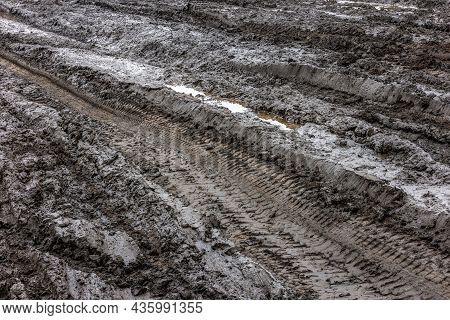 A Broken Rural Country Road. Puddles After Rain On A Dirt Road. Clay, Soil And Puddles At Cloudy Day