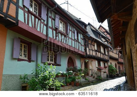 Street with half-timbered medieval houses in Eguisheim village along the famous wine route in Alsace