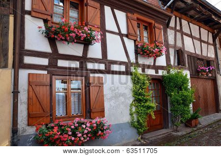 Street with half-timbered medieval houses in Eguisheim village along the famous wine route in Alsace