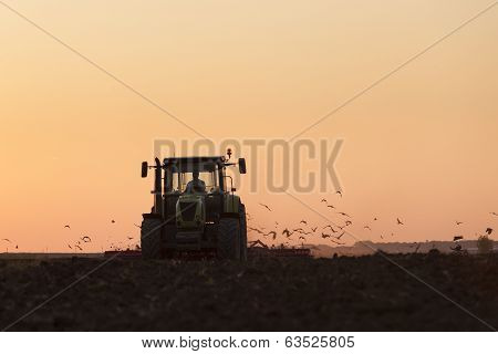 Tractor plowing in dust