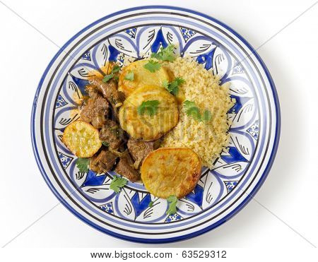 Beef and sweet potato tagine served with couscous and a coriander garnish on a handmade north-African plate, a traditional Moroccan dish from Fez