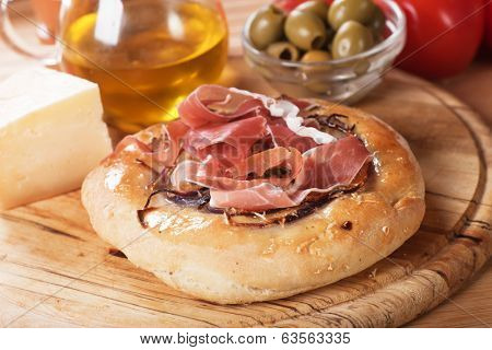 Italian focaccia bread with prosciutto, cheese and green olives