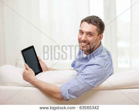 technology, home and lifestyle concept - smiling man working with tablet pc computer at home