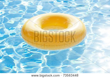 floating ring on blue water swimpool with waves reflecting in the summer sun