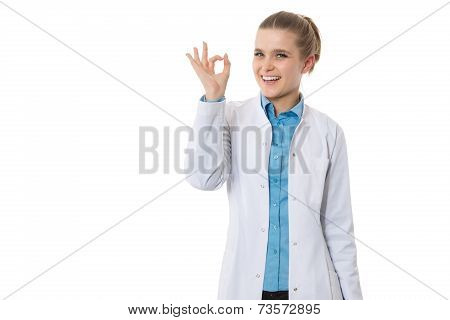 Young smiling doctor showing okay gesture