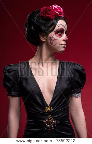 Portrait of young girl in black dress with Calaveras makeup and