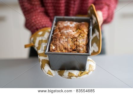 Closeup On Young Housewife Showing Baking Dish With Bread