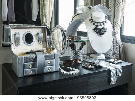 Beauty And Make-up Concept: Table Mirror,sunglasses,j Ewelry And Makeup Brushes On A Black Table