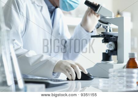 Videnskabsmand med Microscopeand Computer