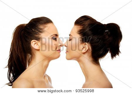 Two attractive sisters standing face to face.