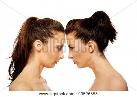 Two attractive sisters standing face to face.