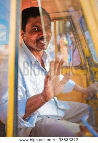 KAMALAPURAM, INDIA - 02 FEBRUARY 2015: Indian delivery man gesticulating while passing by in a three-wheeler