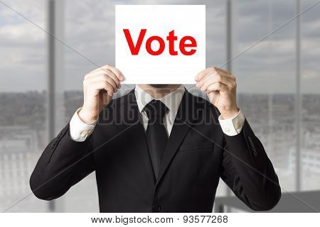 Businessman Hiding Face Behind Sign Vote
