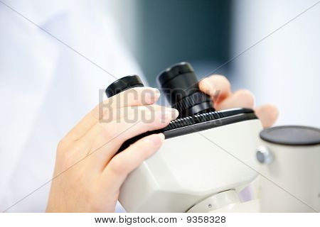Primer plano de un científico mujer mirando a través de un microscopio