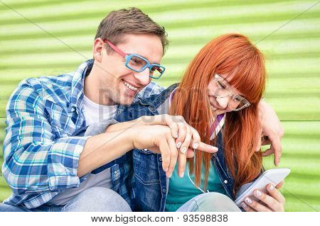 Happy Young Couple Having Fun With Smartphone At Vintage Grunge Location - Concept Of Friendship