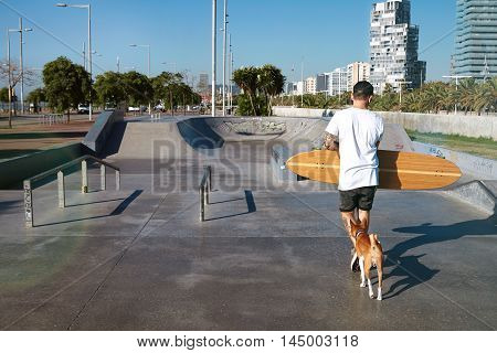 Longboarder In Skate Park With His Dog