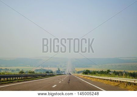 paved picturesque road leading into the distance in the summer