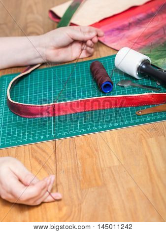 Craftsman Sews New Belt For Leather Bag