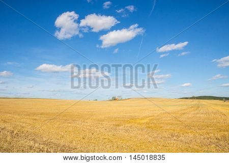 Straw Bales Harvest on Stubble field under blue sky