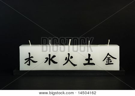 ห้าเซนญี่ปุ่นเทียนกับ ideograms ผ่านถาดไม้เป็นสีดำ