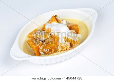 Sweet pumpkin in coconut milk on white background.