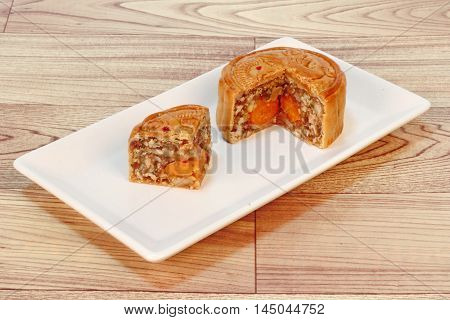 A dish of Mooncake filling five seed and salt eggs on wood. Close up focus.