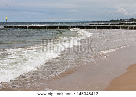 The gentle waves of the waters of the Baltic Sea reaches the sandy beach in Kolobrzeg in Poland