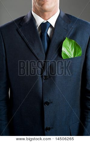 Stilvolle Geschäftsmann mit einem frischen grünen Blatt in der Tasche. Green Business Konzept, kümmern uns um die 