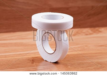 Pair roll's of double sided tape on wooden background