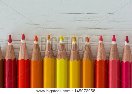 Sharp colorful crayons aligned on a white background