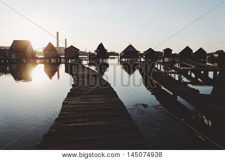 Old wooden pier, and small houses over the lake