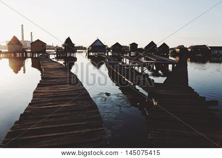 Old wooden pier, and small houses over the lake