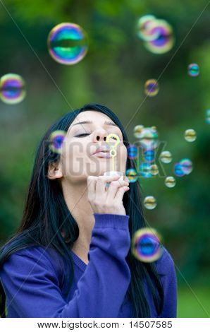 Młode piękne dziewczyny dmuchanie baniek w przyrodzie, symbol nadziei i aspiracji