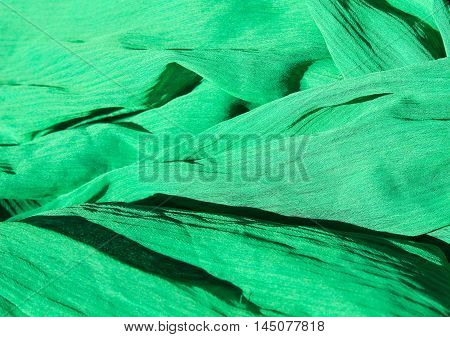 Green fabric abstract background. Chiffon cloth pattern