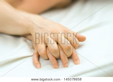 Passionate couple making love in bed. Body part view