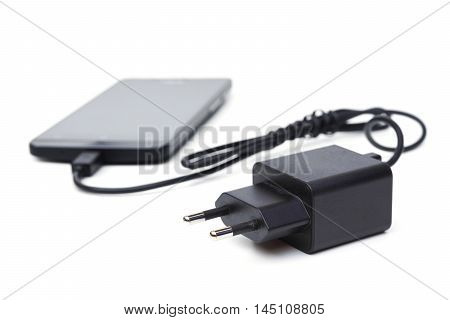 Mobile phone and adapter charger isolated on white