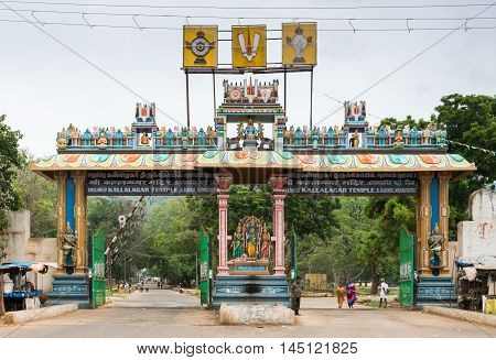 Madurai India - October 19 2013: Monumental entrance gate to domain of Kallalagar Vishnu Temple shows several of his avatars. People in photo.