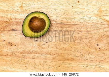 A delicious half avocado on wooden table