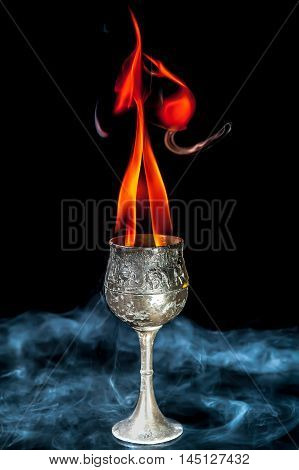 Wine goblet with Fire flames with smoke on black background
