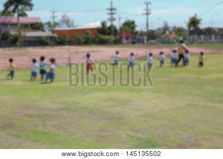 Student Kindergarten. Blur blurred student Kindergarten running on grass in school Teachers have run lead.